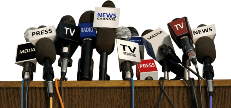 Microphones with press, TV, radio, and media labels at a podium for voting before tolls campaign; press conference setup for transportation toll reform advocacy.